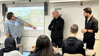 Tre män står framför en klass - från Norrenergi och Arbetsmarknadskunskap - och föreläser om hur det är att jobba i energibranschen. En av dem pekar på en bild på tavlan.